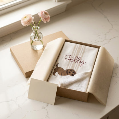 The towel in an open kraft gift box with a note card