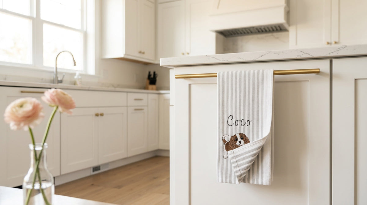 Personalized pet towel hanging from a brass rail in a warm kitchen