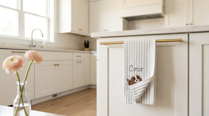 Personalized pet towel hanging from a brass rail in a warm kitchen