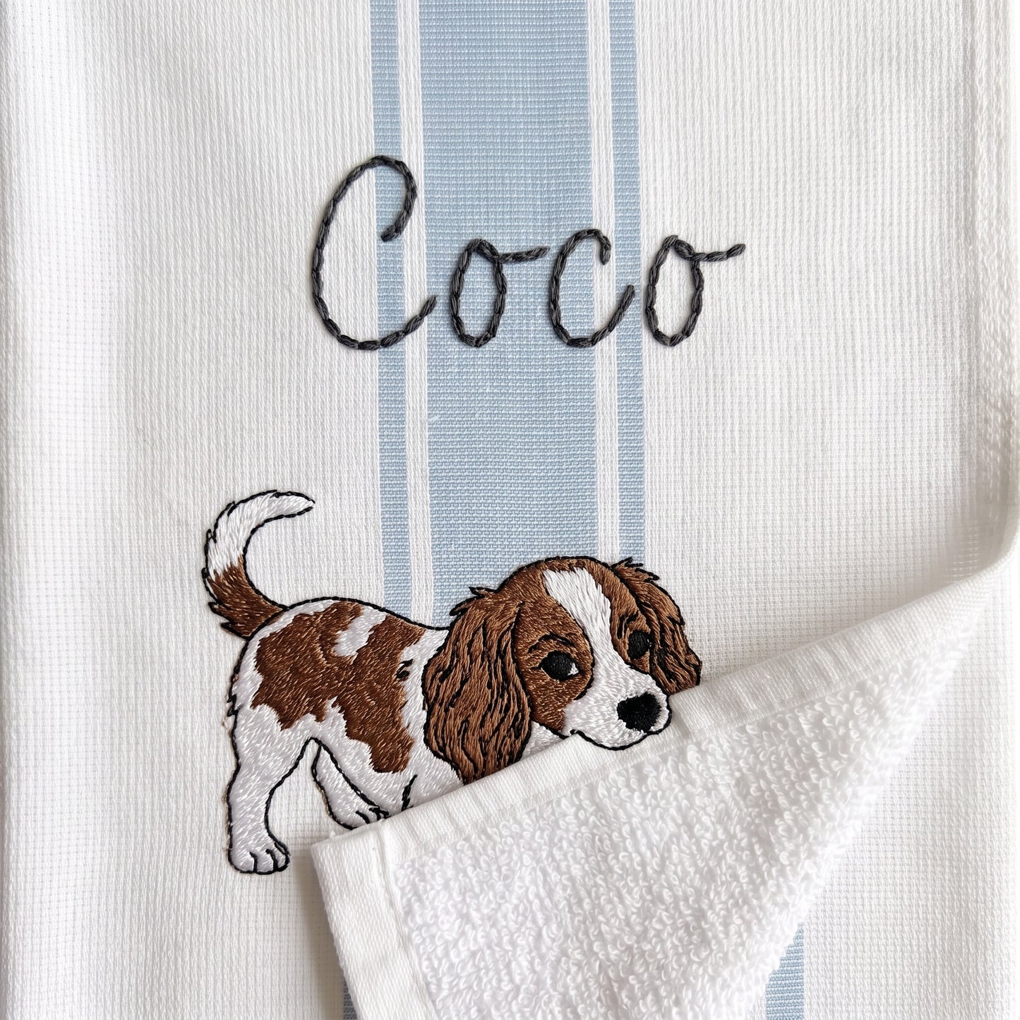Example Cavalier King Charles Spaniel embroidery named Coco on the light blue stripe towel