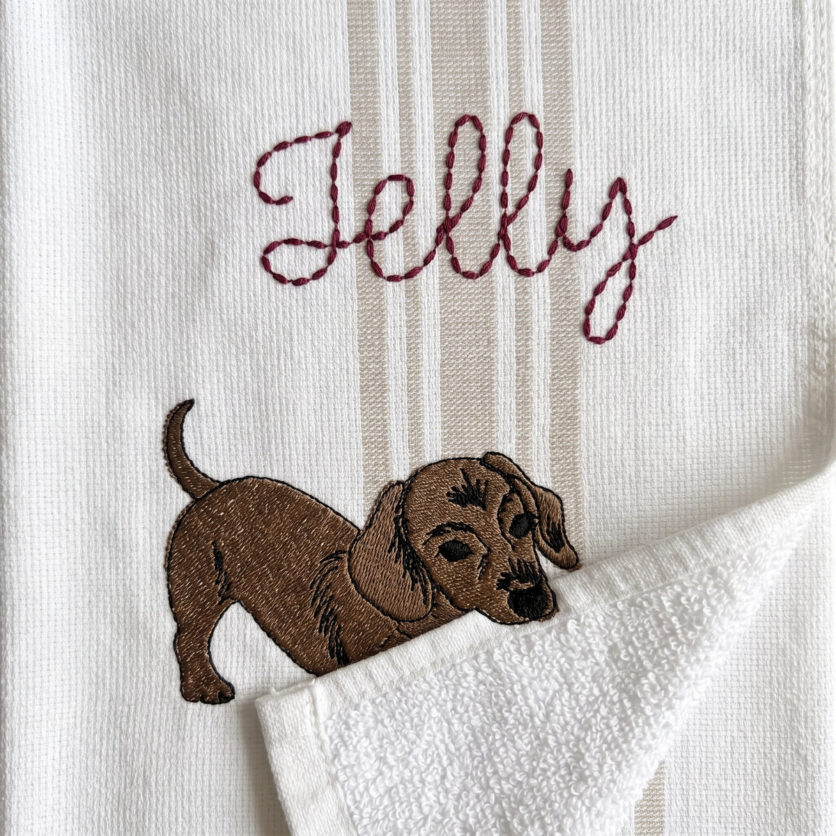 Example dachshund embroidery named Jelly on the beige stripe towel