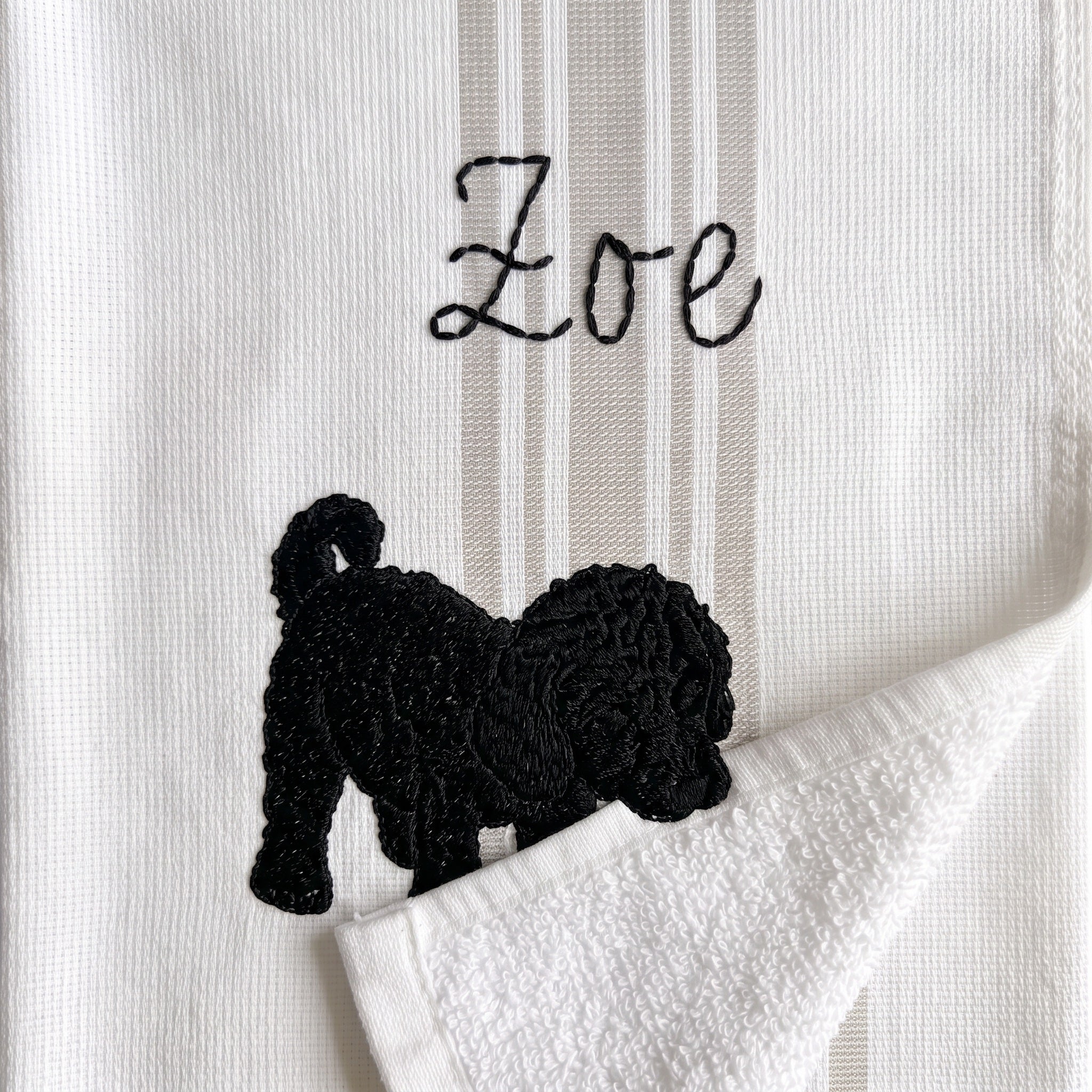 Example curly black pup embroidery named Zoe on the gray stripe towel